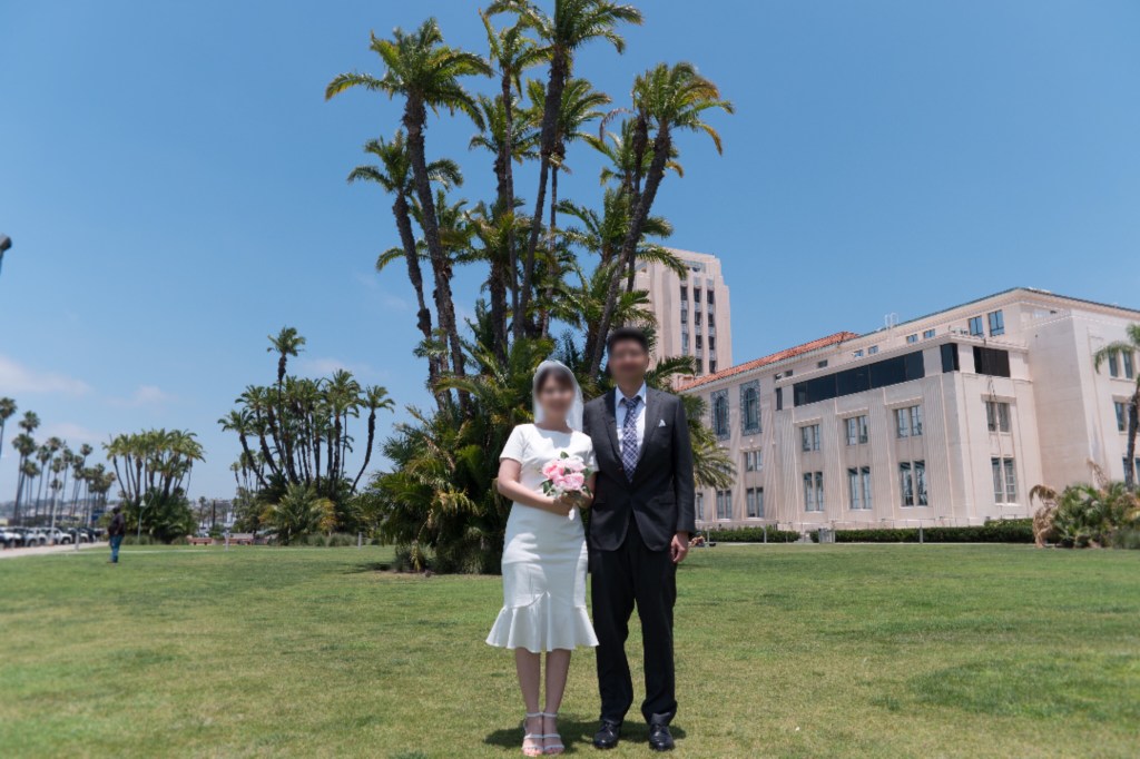 샌디에고 카운티 센터 앞에서 신랑 신부가 결혼 기념 사진을 찍는다